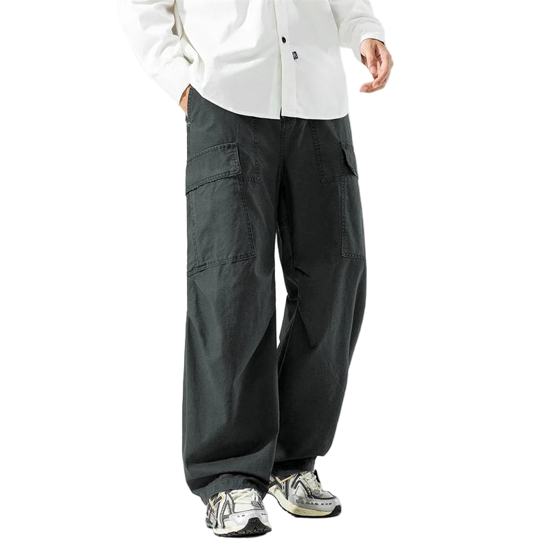 Person wearing dark gray cargo pants and a white shirt on a light gray background