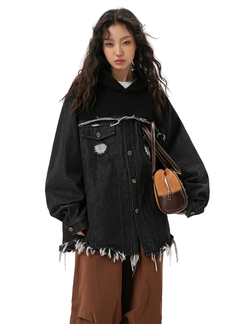 Person wearing a black distressed denim jacket with a white background
