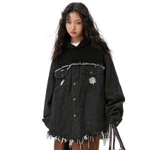 Person wearing a black distressed denim jacket on a white background