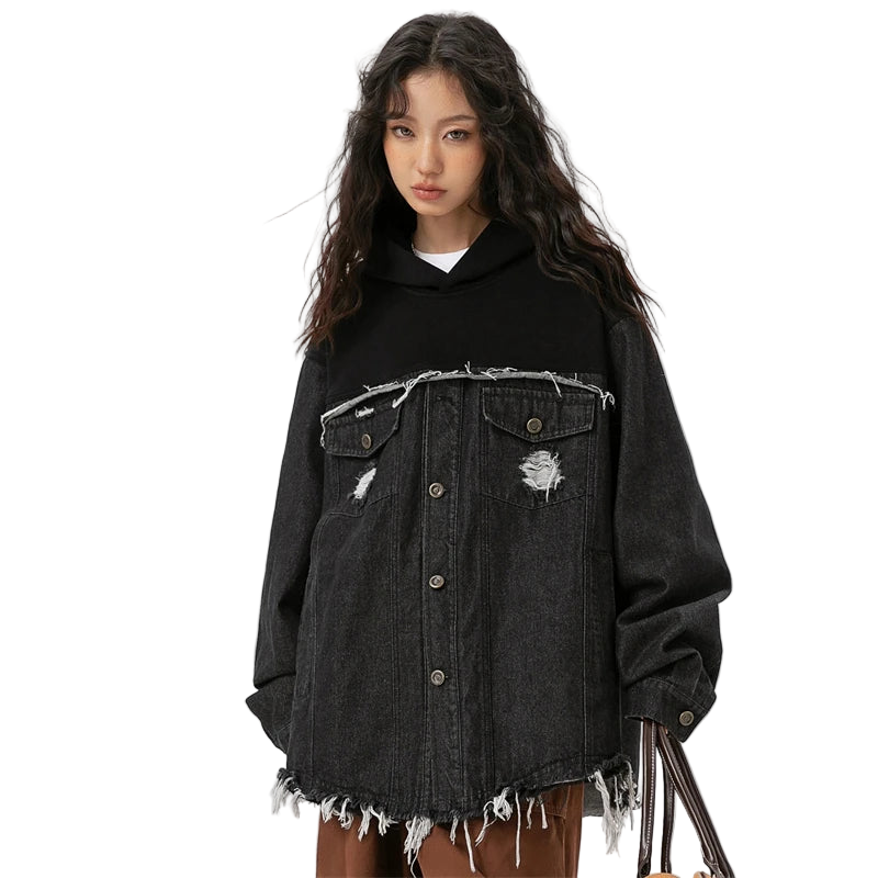 Person wearing a black distressed denim jacket on a white background