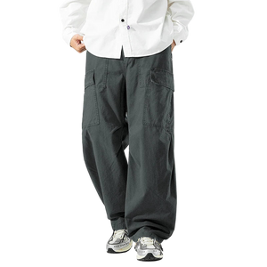 Person wearing gray cargo pants and a white shirt on a white background
