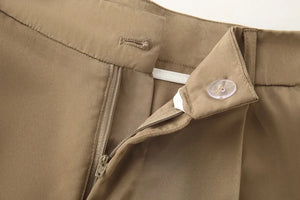 Close-up of a brown jacket with a zipper and button details.