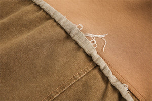 Close-up of brown fabric with a visible seam and thread