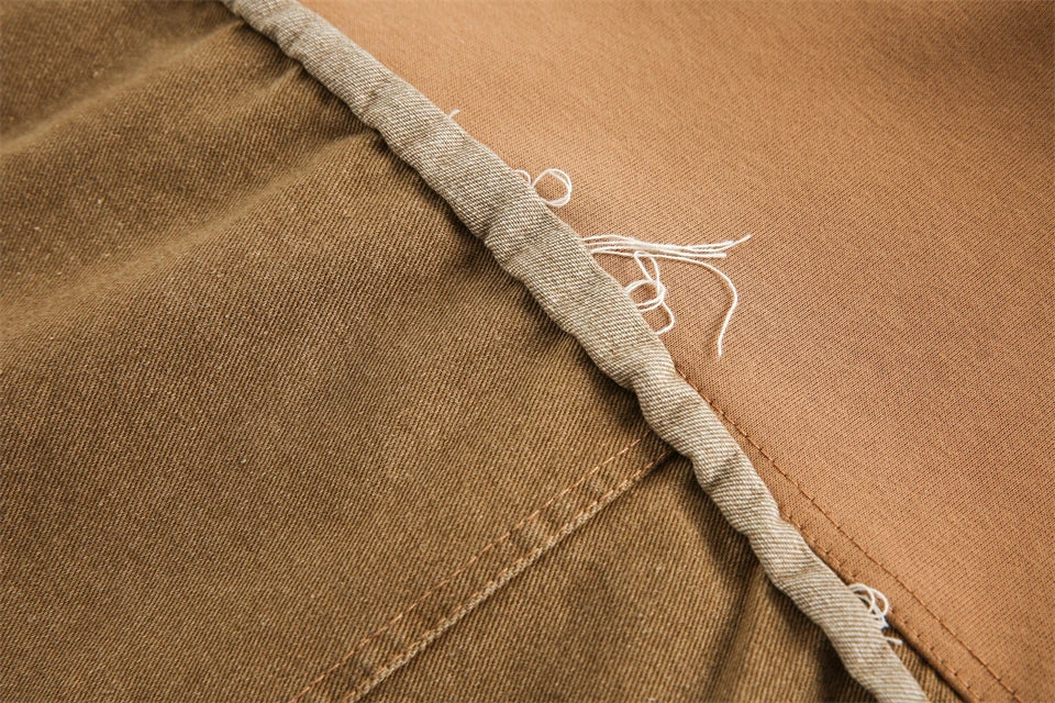 Close-up of brown fabric with a visible seam and thread