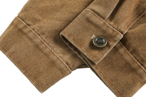 Close-up of a brown jacket with a button on a light gray background