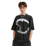 Person wearing a black t-shirt with a white graphic design on a plain background