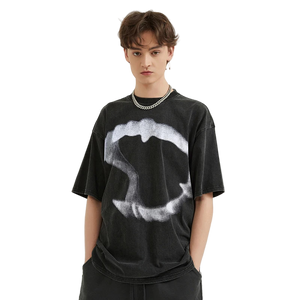 Person wearing a black t-shirt with a white graphic design on a plain background