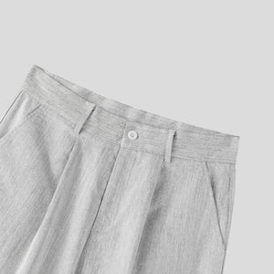 Gray pleated pants with a button on a light gray background
