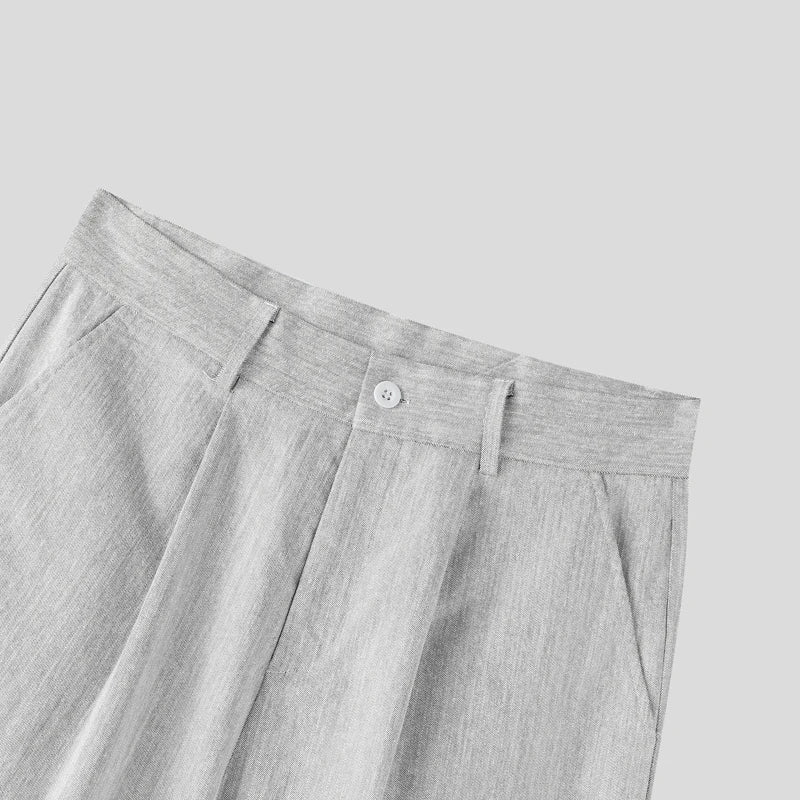Gray pleated pants with a button on a light gray background