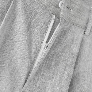 Close-up of a gray denim shirt with a zipper and button details.