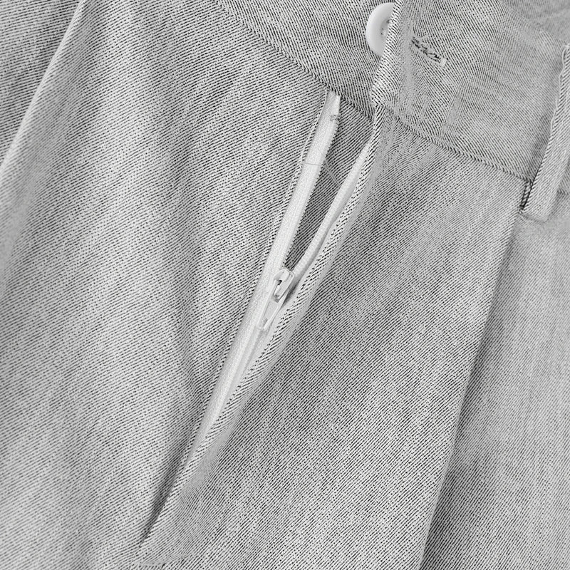 Close-up of a gray denim shirt with a zipper and button details.