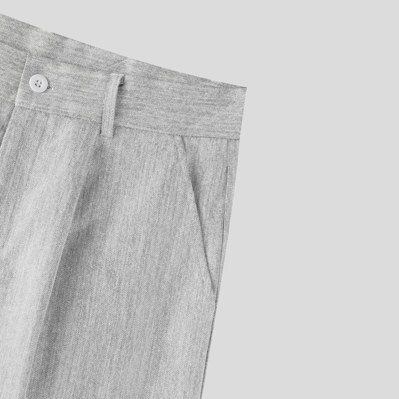 Close-up of gray pants with a button on a light gray background