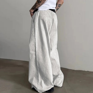 Person wearing light gray wide-leg pants against a plain background