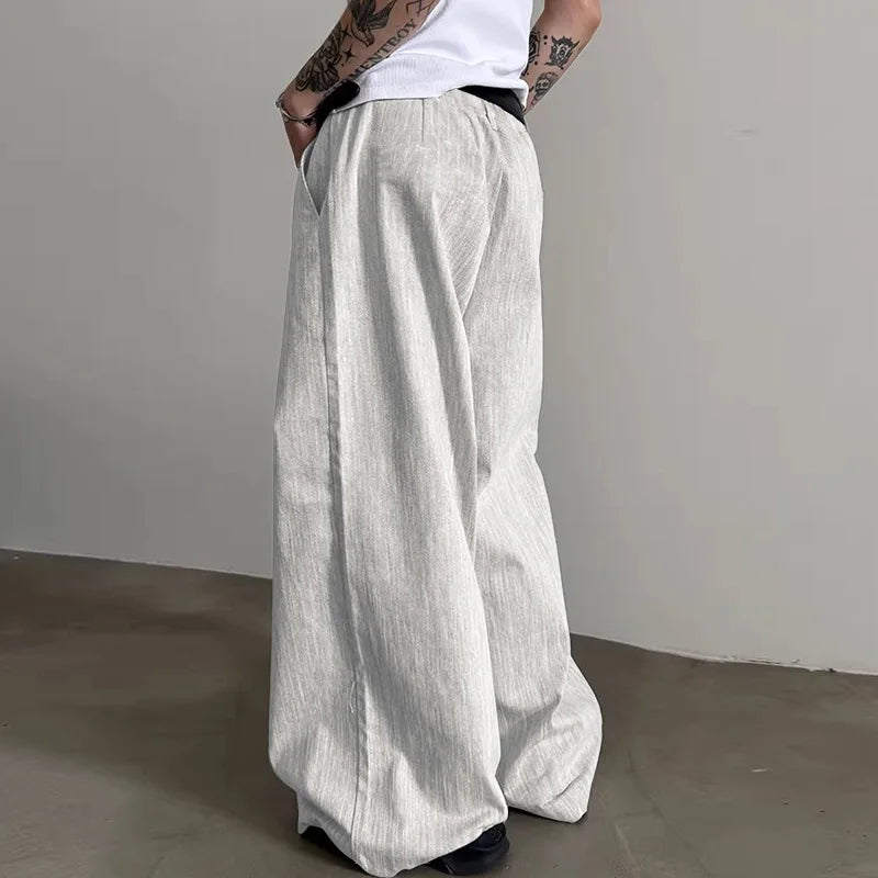 Person wearing light gray wide-leg pants against a plain background