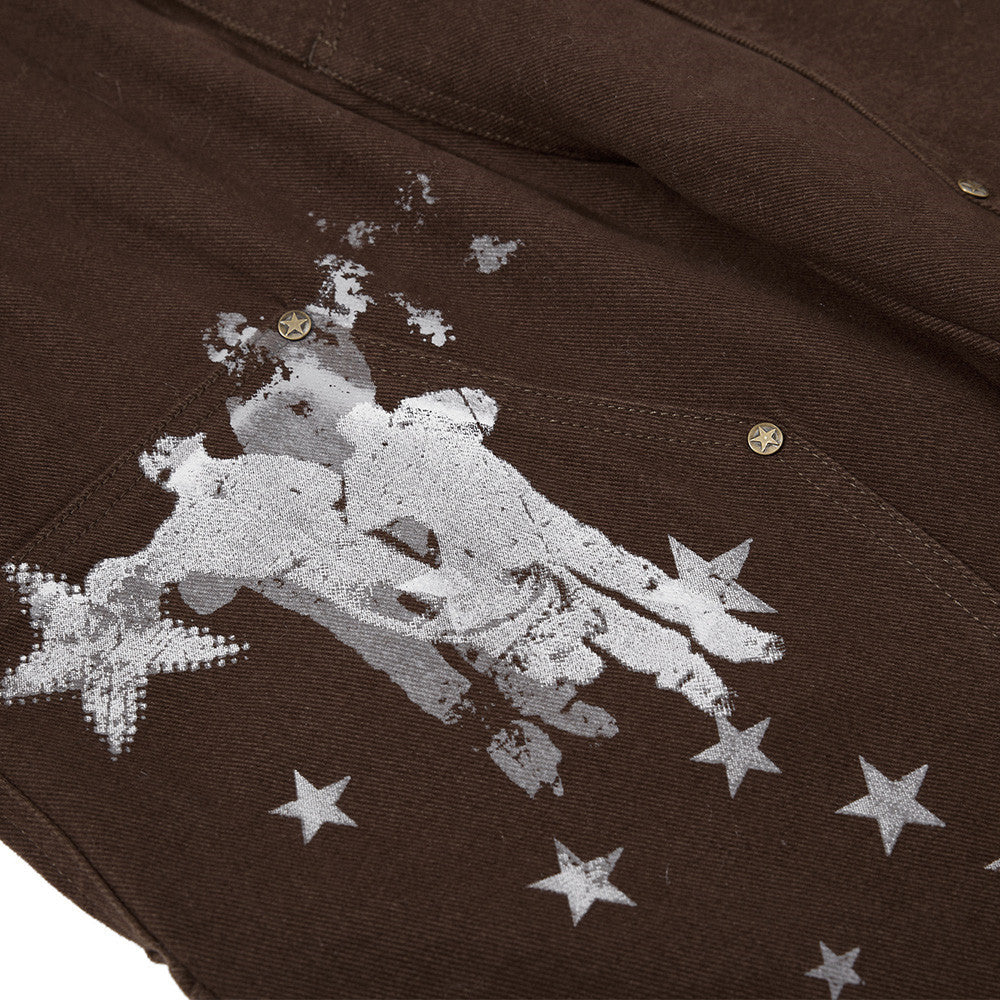 Close-up of a brown fabric with white embroidered design and stars.