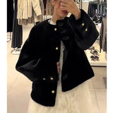 Person wearing a black coat with gold buttons in a store setting