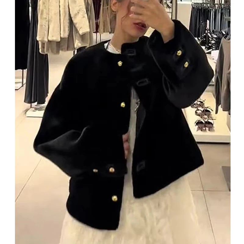 Person wearing a black coat with gold buttons in a store setting