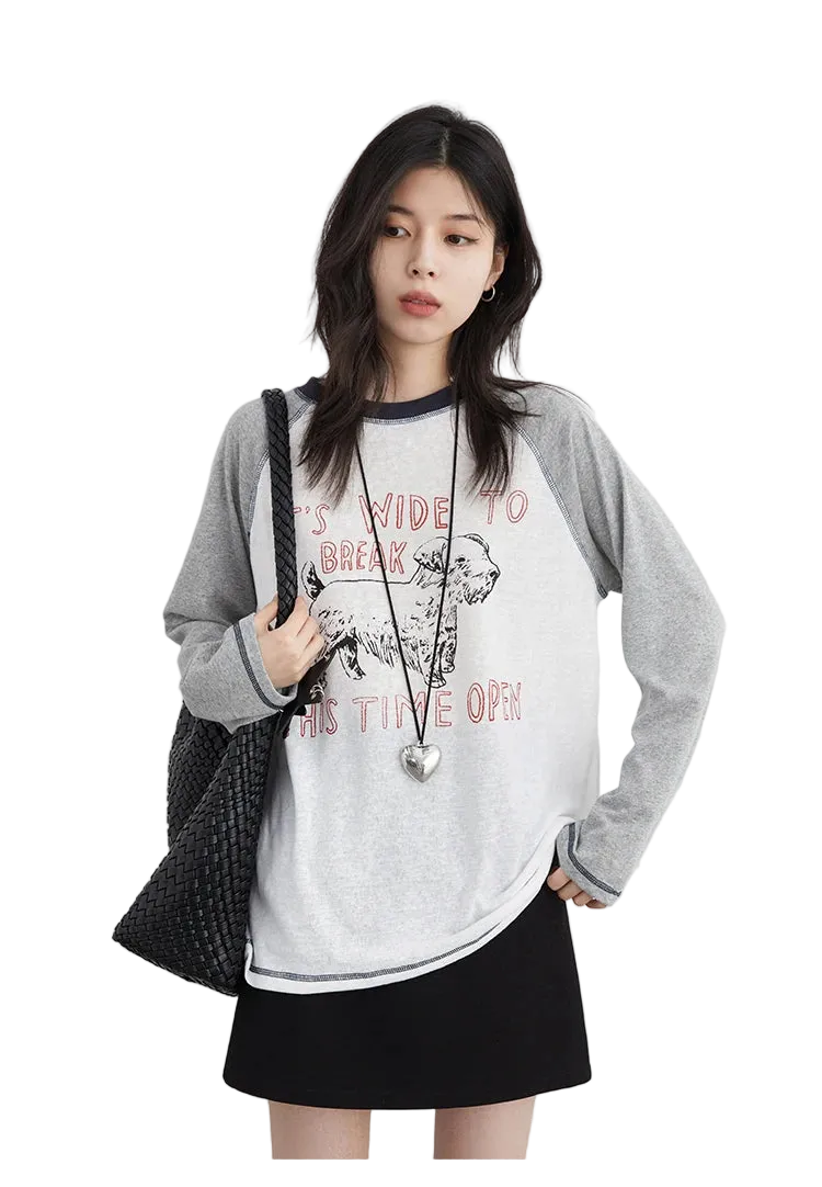 Woman wearing a gray and white long-sleeve shirt with text and a black skirt on a white background