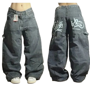 Pair of baggy jeans with branding on a wooden floor.