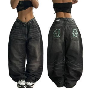Black distressed jeans with green lettering on a plain background