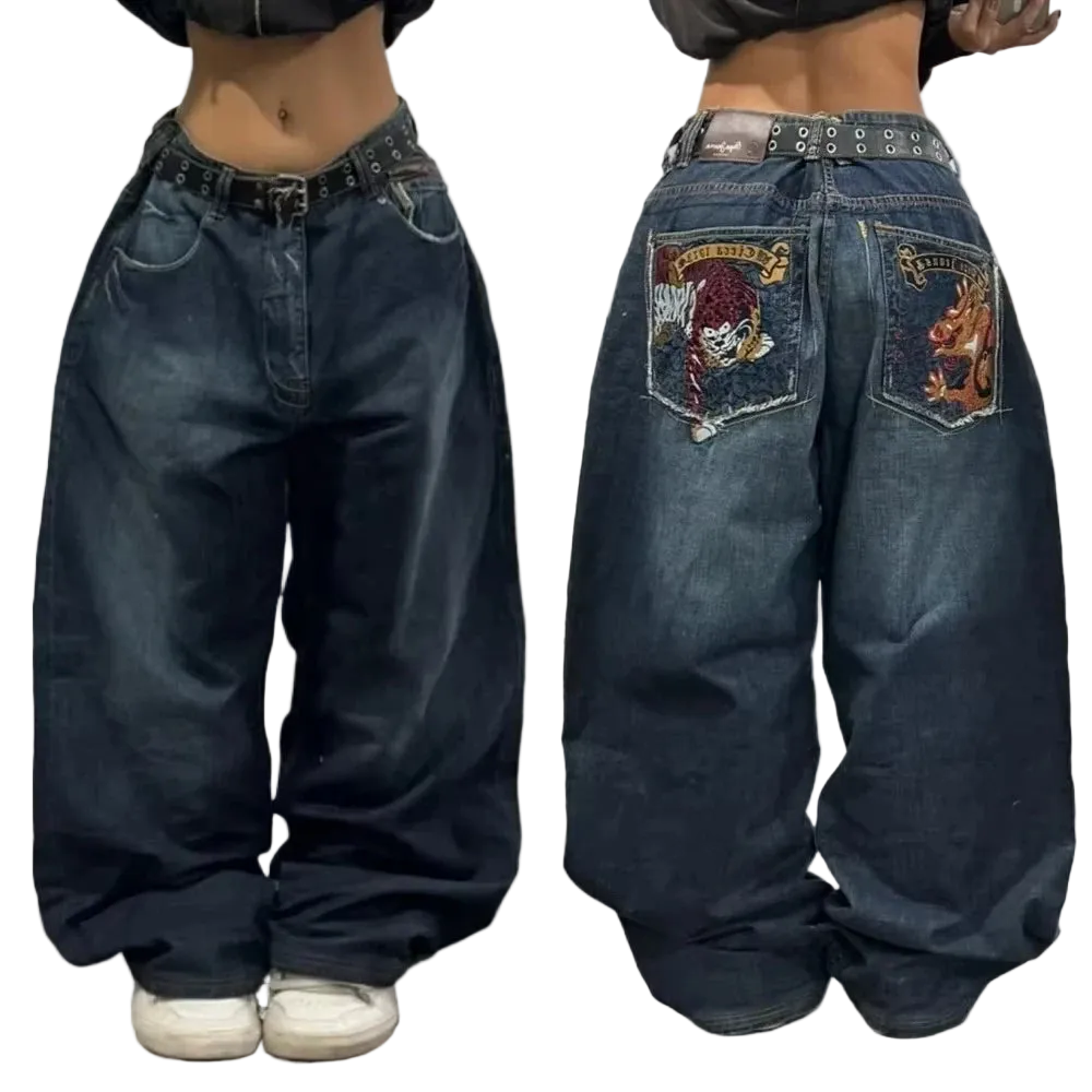 Blue jeans with embroidered designs on the back pocket worn by a person.
