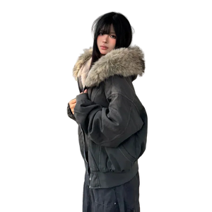 Person wearing a dark green parka with a fur-lined hood on a wooden deck.