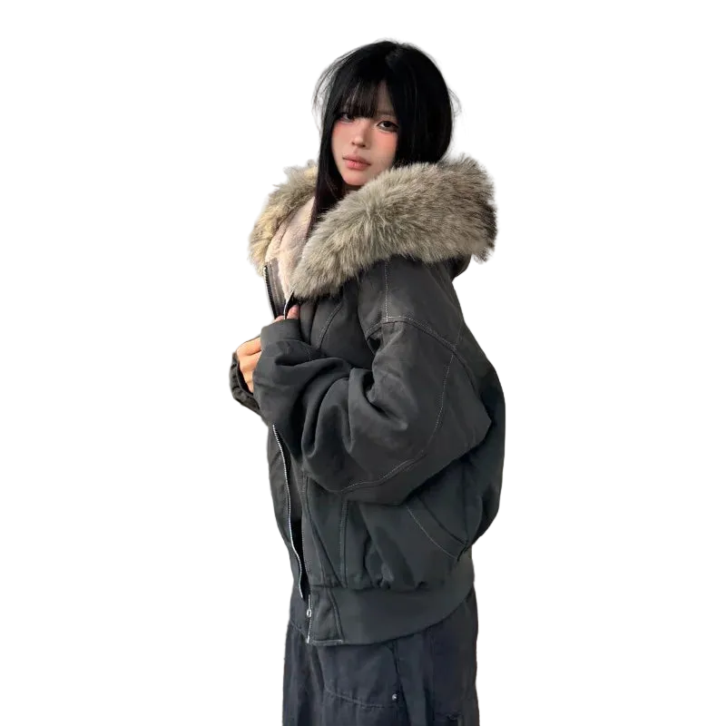 Person wearing a dark green parka with a fur-lined hood on a wooden deck.